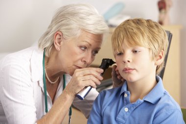 British GP examining young boy's ear clipart