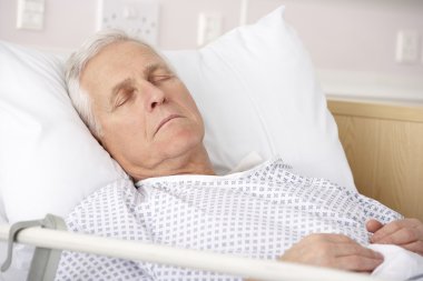 Senior man asleep in hospital bed clipart