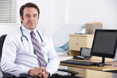 Portrait UK doctor sitting at desk clipart