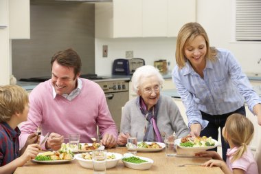 Multi-generation family sharing meal together clipart