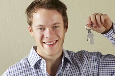 Studio Shot Of Young Man Holding Keys To First Home clipart
