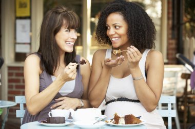 Pregnant women sitting outside cafe clipart