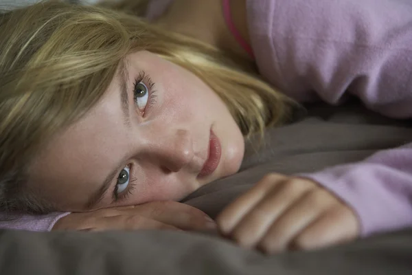 Depressief tienermeisje liggen in slaapkamer — Stockfoto