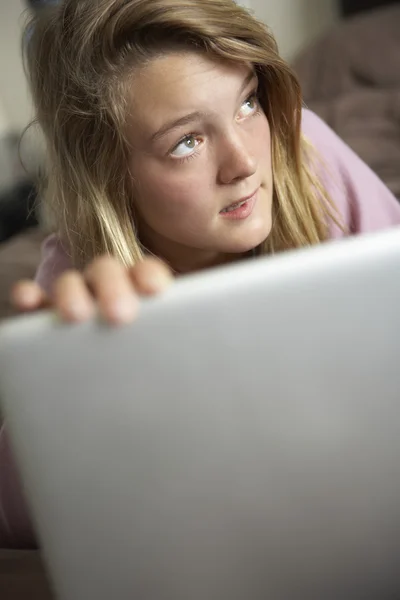 Schuldig op zoek tienermeisje laptop thuis gebruiken — Stockfoto