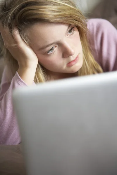 Olycklig tonårstjej med laptop hemma — Stockfoto