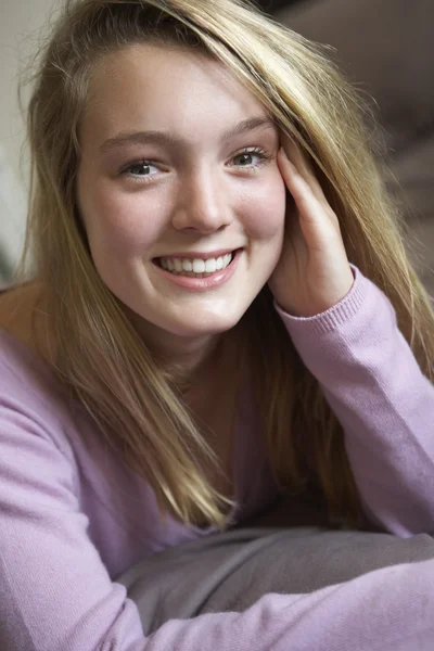 Glad tonårig flicka sitter i sovrummet — Stockfoto