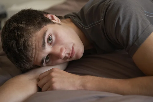 Depressed Teenage Boy Lying In Bedroom — Stock Photo, Image