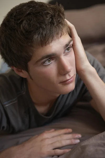 Depresivní dospívající chlapec ležící v ložnici — Stock fotografie