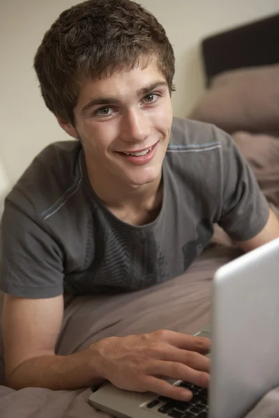 Хлопчик-підліток використовує ноутбук вдома — стокове фото
