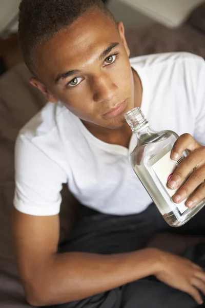 Adolescente menino deitado no quarto bebendo — Fotografia de Stock