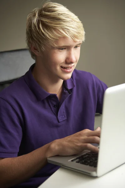 Tonårspojke med laptop hemma — Stockfoto