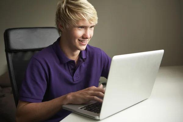 十几岁的男孩在家里使用的便携式计算机 — 图库照片
