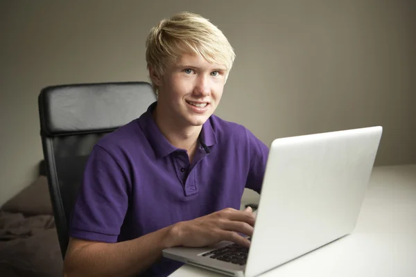 Dospívající chlapec doma pomocí přenosného počítače — Stock fotografie