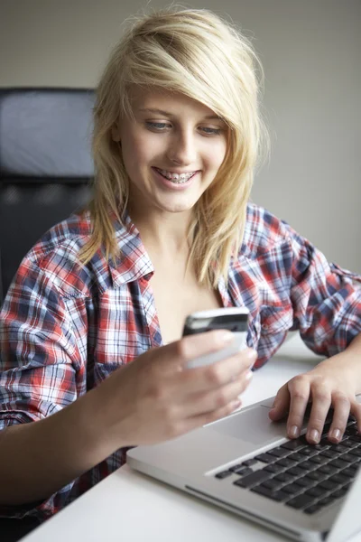 Tonårig flicka använder laptop och mobil hemma — Stockfoto
