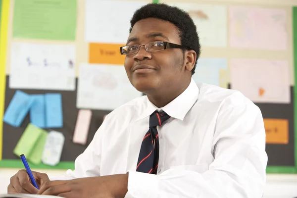 Estudiante adolescente masculino que estudia en clase — Foto de Stock