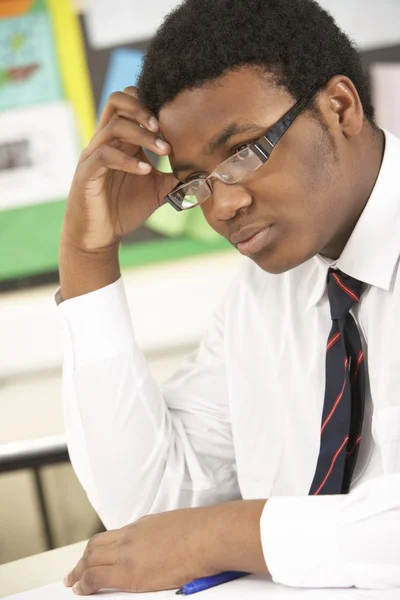Betonade manlig teenage student som studerar i klassrummet — Stockfoto