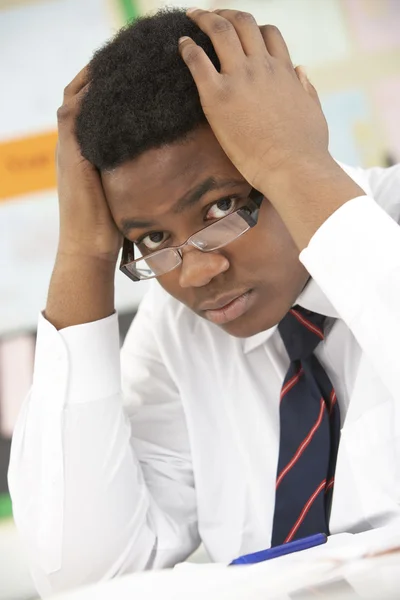 Gestresste männliche Teenager studieren im Klassenzimmer — Stockfoto