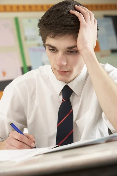 Varón estresado estudiante adolescente que estudia en el aula —  Fotos de Stock
