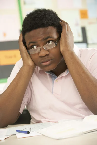 Betonade manlig teenage student som studerar i klassrummet — Stockfoto