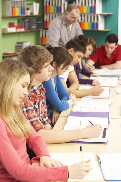 Estudantes adolescentes estudando na sala de aula com professor — Fotografia de Stock