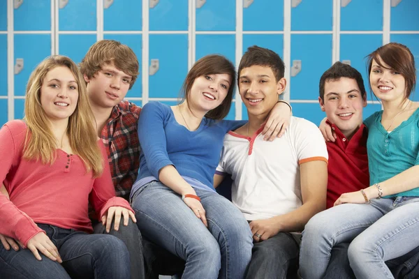 Adolescentes estudantes relaxando por armários na escola — Fotografia de Stock