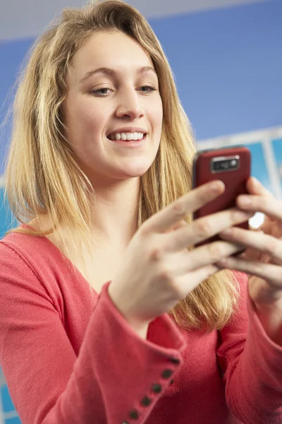 女性青少年学生使用手机的储物柜中学校 — 图库照片