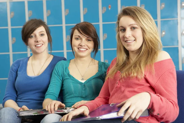 Estudantes adolescentes do sexo feminino relaxando por armários na escola — Fotografia de Stock