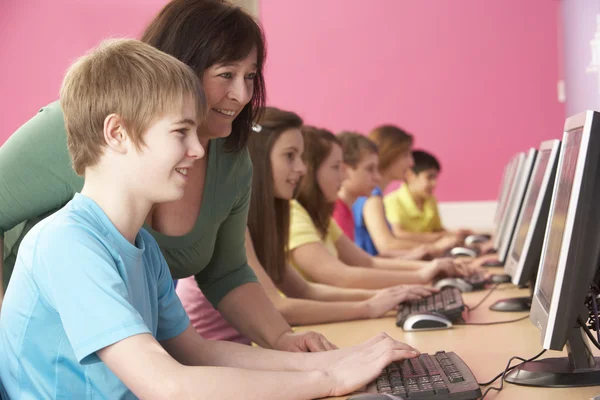 Estudiantes adolescentes en clase de TI usando computadoras con tutor —  Fotos de Stock