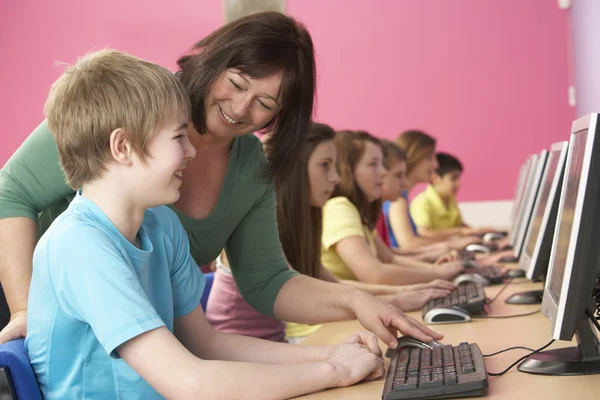 Estudiantes adolescentes en clase de TI usando computadoras con tutor —  Fotos de Stock