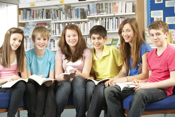 Teenage studenten in bibliotheek boeken lezen — Stockfoto