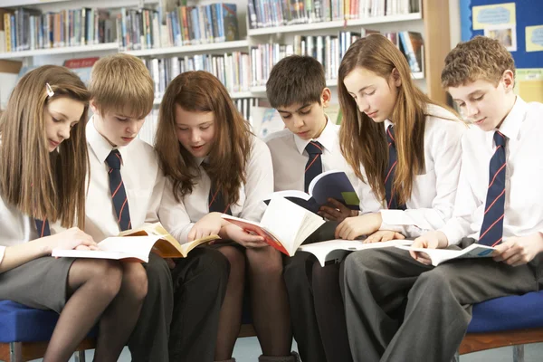 Nastoletnich uczniów w bibliotece czytanie książek — Zdjęcie stockowe