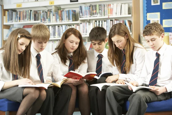 Estudantes adolescentes na biblioteca leitura de livros — Fotografia de Stock