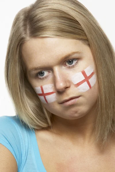 Грустный молодой поклонник женских видов спорта с флагом Святого Жоржа, раскрашенным на лице — стоковое фото