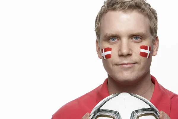 Fiatal férfi focirajongó a dán zászlót arcán festett — Stock Fotó