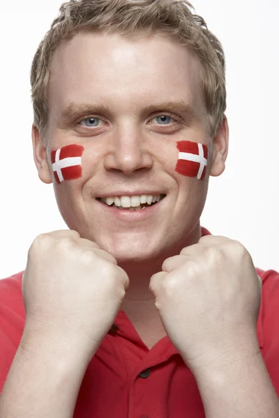 Fiatal férfi sport rajongó a dán zászlót arcán festett — Stock Fotó