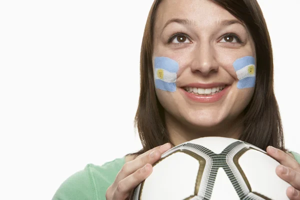 Ung kvindelig fodbold fan med argentinsk flag malet på ansigt - Stock-foto