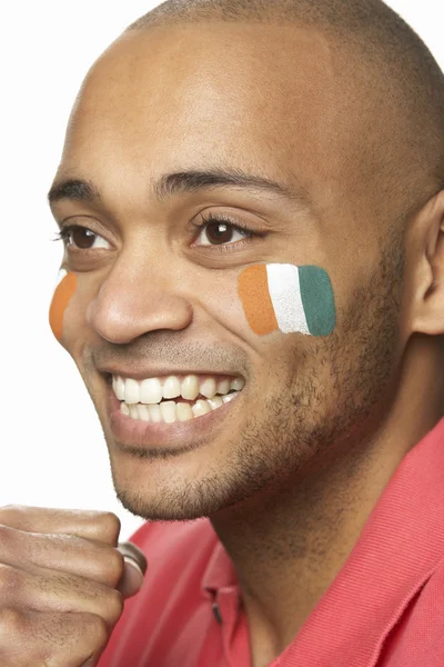 Jeune fan de sport masculin avec drapeau de la Côte d'Ivoire peint sur le visage — Photo