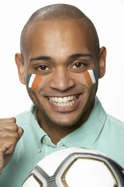 Jovem ventilador de futebol masculino com bandeira da Costa do Marfim pintado no rosto — Fotografia de Stock