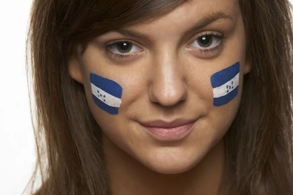 Jonge vrouwelijke sportenventilator met Hondurese vlag geschilderd op gezicht — Stockfoto