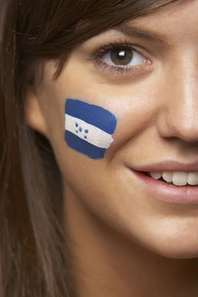 Ventilador deportivo femenino joven con bandera hondureña pintada en la cara —  Fotos de Stock