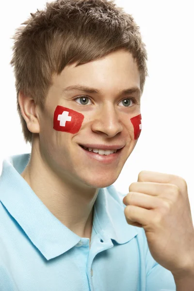 A svájci lobogó arcán festett fiatal férfi sport rajongó — Stock Fotó