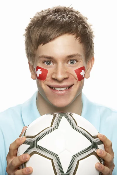 Ventilador de fútbol masculino joven con bandera suiza pintada en la cara — Foto de Stock