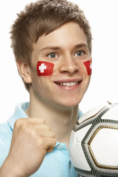 Jovem ventilador de futebol masculino com bandeira suíça pintada no rosto — Fotografia de Stock