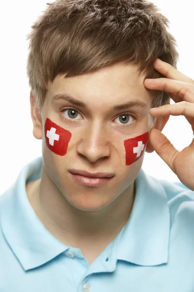 失望的年轻男性体育迷与瑞士国旗画在 fa — 图库照片