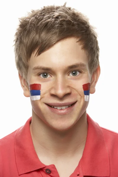 Ventilador de esportes masculino jovem com bandeira sérvia pintada no rosto — Fotografia de Stock