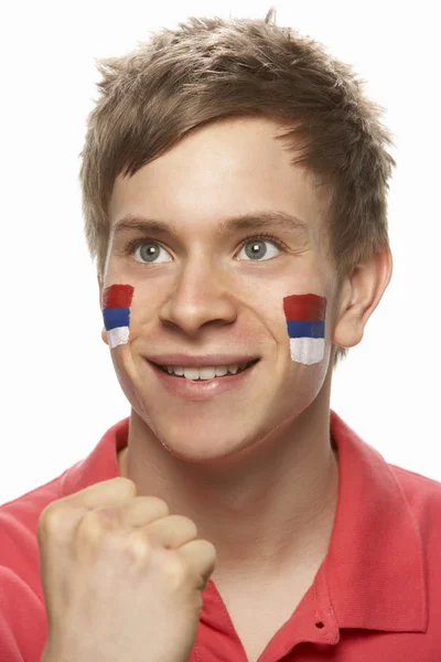 Mladý samec sportovní fanoušek s srbskou vlajkou na obličej — Stock fotografie