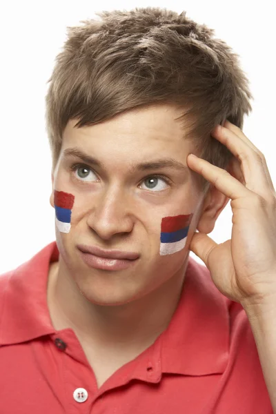 Decepcionado jovem masculino esportes ventilador com sérvio bandeira pintado no — Fotografia de Stock
