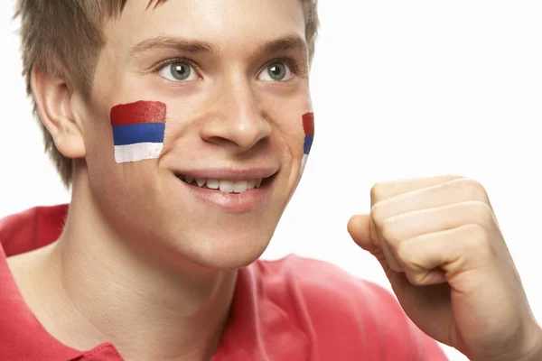Jovem fã de futebol masculino com bandeira sérvia pintada no rosto — Fotografia de Stock