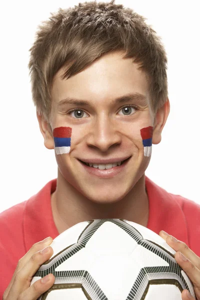 Junger männlicher Fußballfan mit serbischer Fahne im Gesicht — Stockfoto