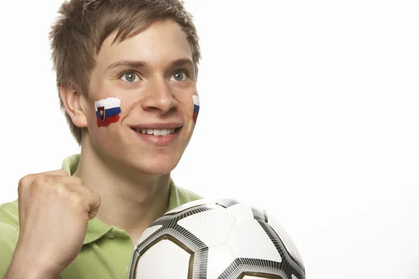 Junger männlicher Fußballfan mit slowakischer Fahne im Gesicht — Stockfoto